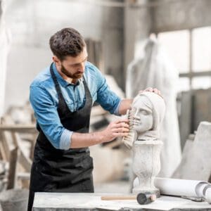 Sculptor cleaning a stone bust.