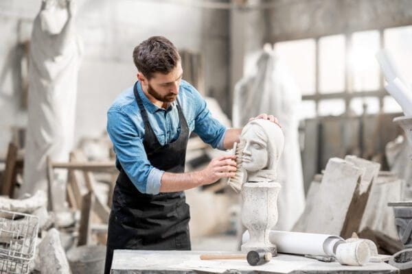 Sculptor cleaning a stone bust.